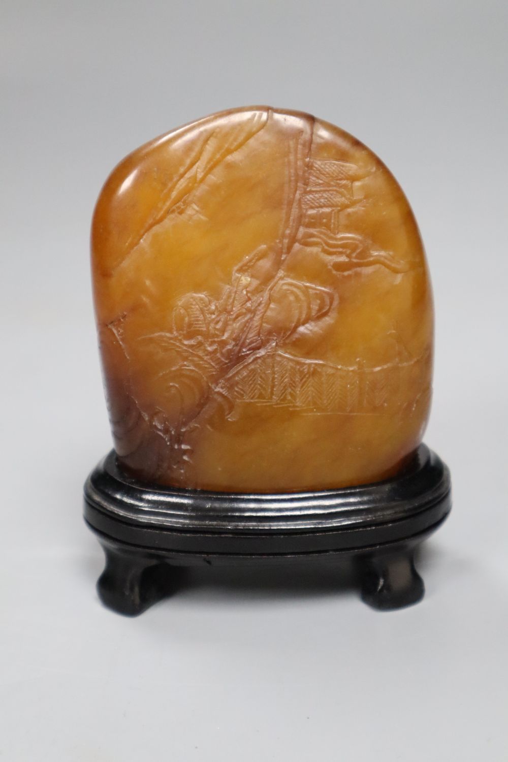 A Chinese amber coloured soapstone seal, late 19th / early 20th century, wood stand, overall height 10.5cm